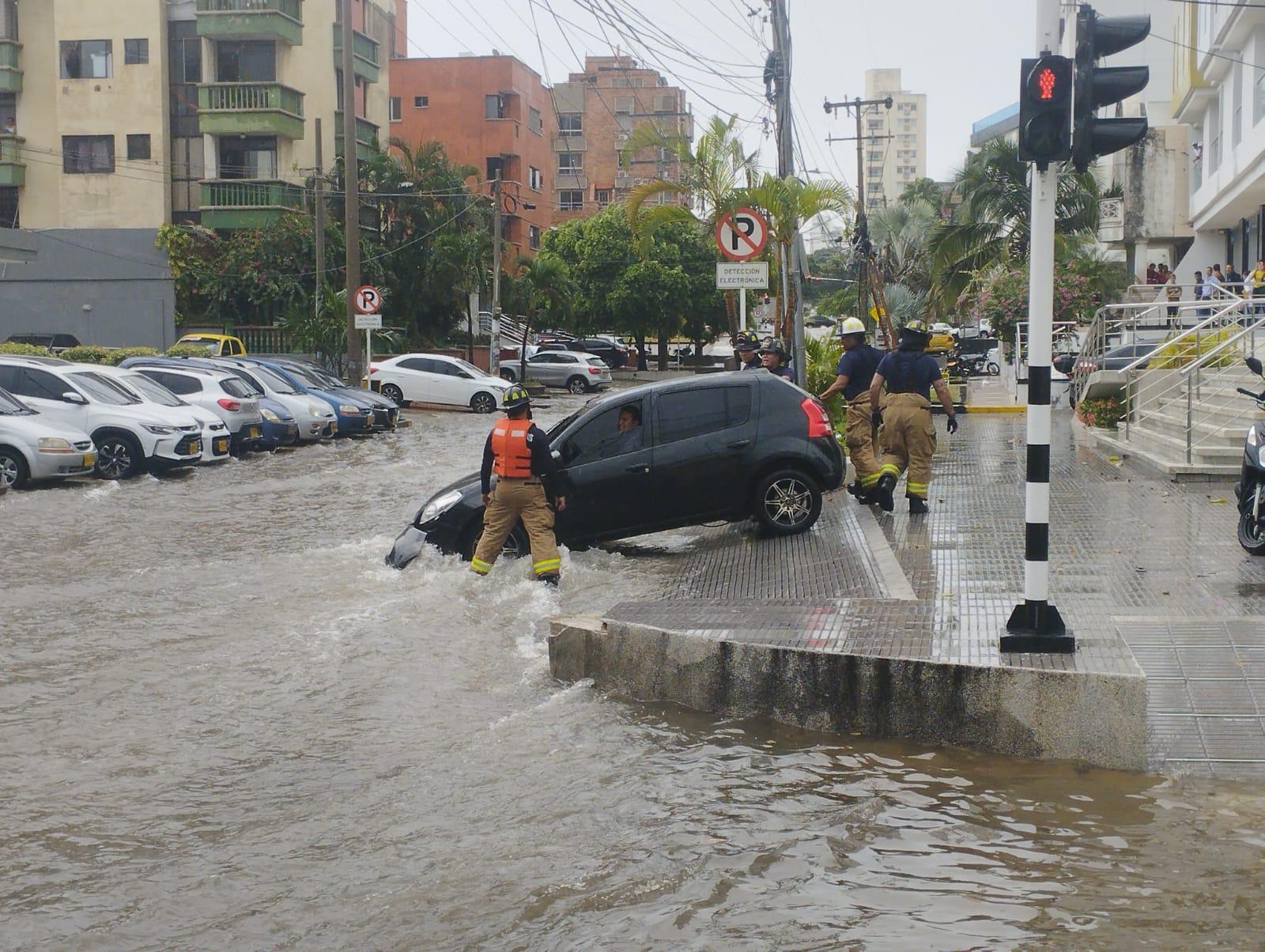 Dos vehículos atrapados en arroyo de la 85 durante el aguacero de este jueves.