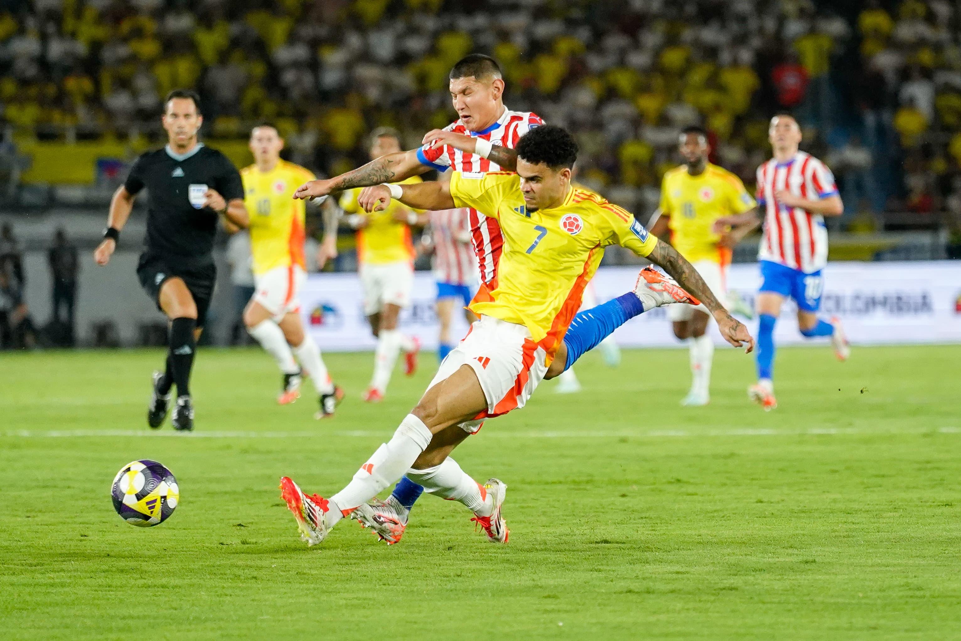 Luis Díaz en disputa del balón contra un rival paraguayo.