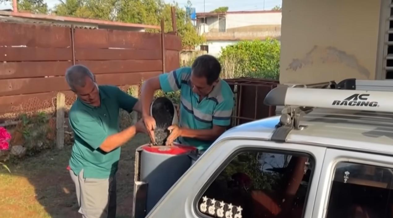 El cubano colocando el carbón para que el vehículo funcione. 