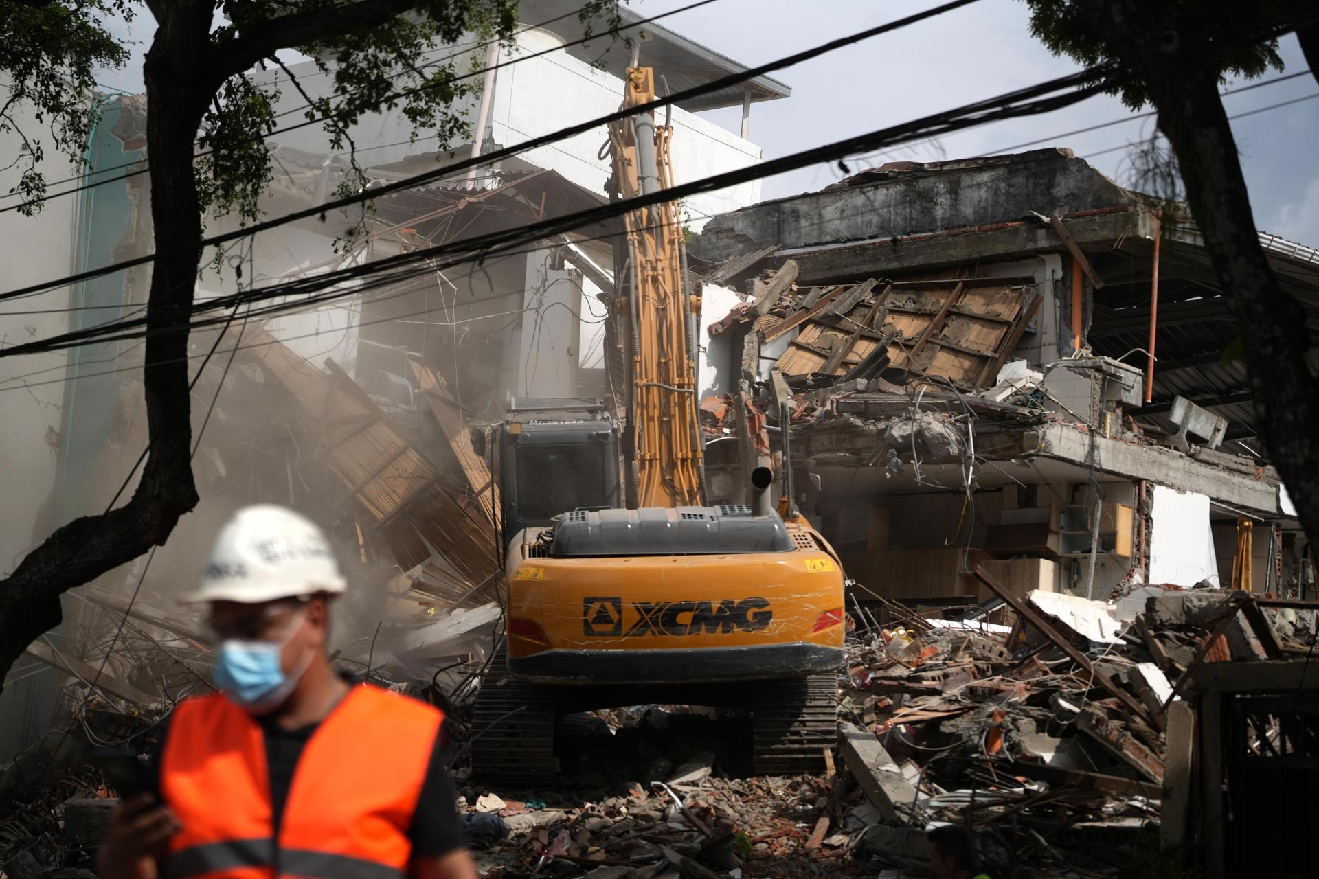 Una retroexcavadora demoliendo un edificio afectado por el terremoto del pasado 10 de agosto, en Cali.