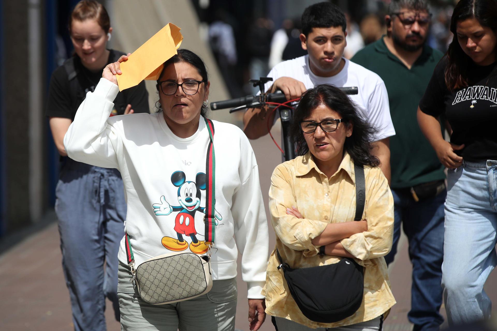 Personas caminan por una calle durante una jornada de altas temperaturas.